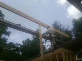 Carpenter setting a ridge beam over a new addition frame — Ice Dam Removal by Roofing Brothers in Willis