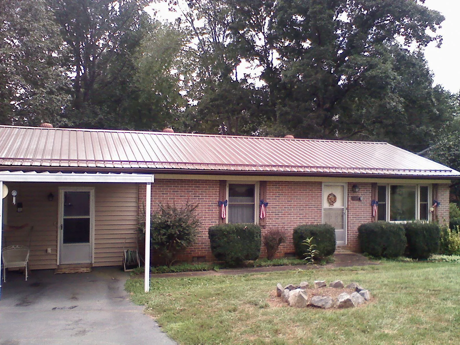 Bronze metal roof and carport on a brick ranch home — Roof Repair work by our crew in Willis