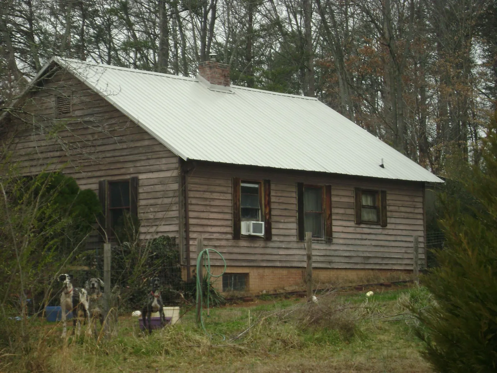 White metal roof on an old wood sided farmhouse, from a Metal Roof Installation job in Willis
